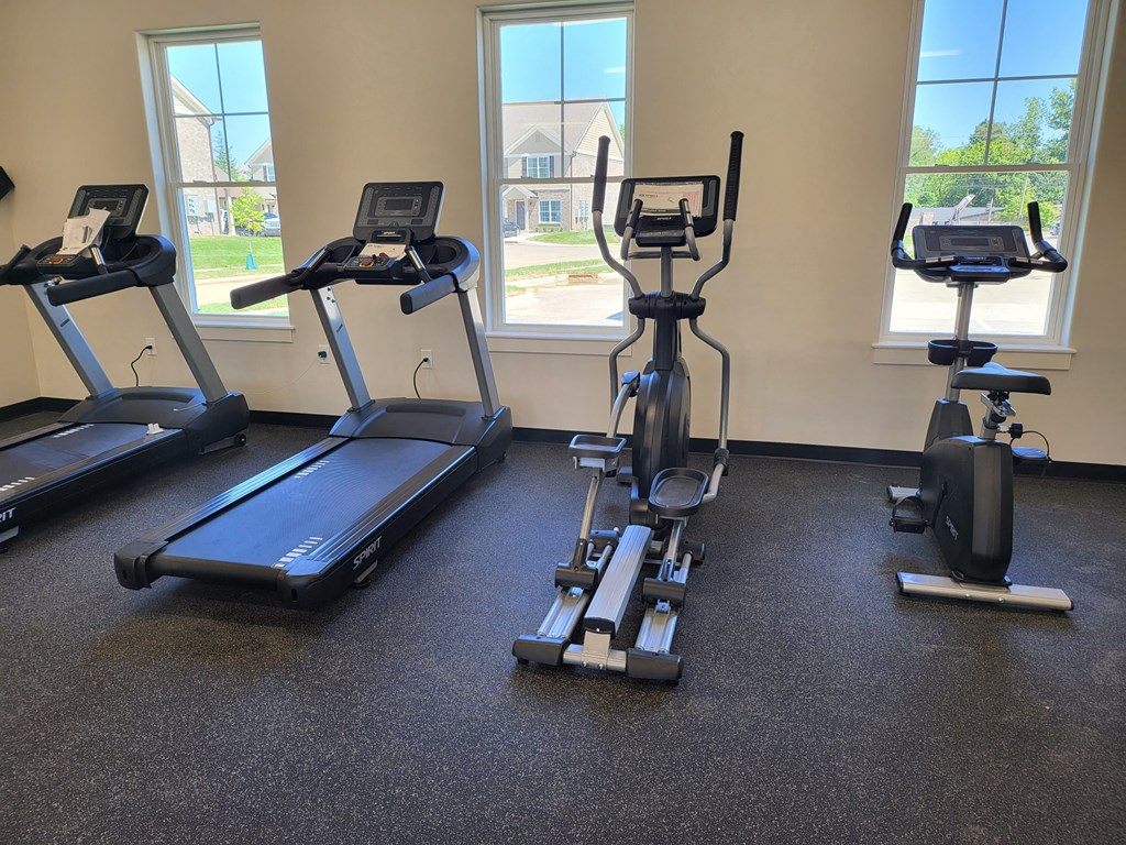 a gym with three exercise bikes on the floor
