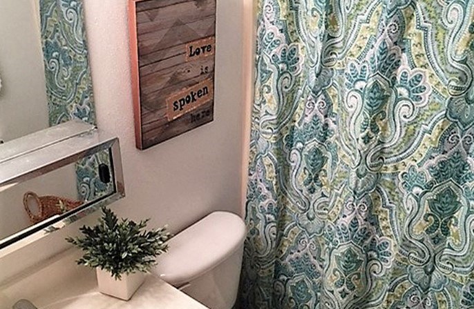 a bathroom with a white toilet and a blue shower curtain