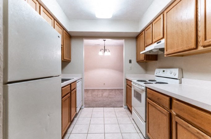 a kitchen with white appliances and wooden cabinets