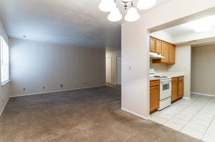 an empty living room with a kitchen in it