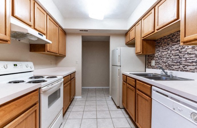 a kitchen with white appliances and wooden cabinets
