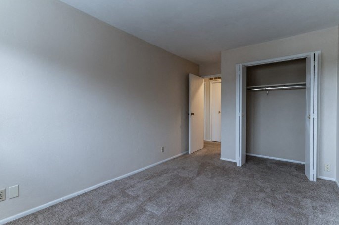 an empty living room with a door to a closet