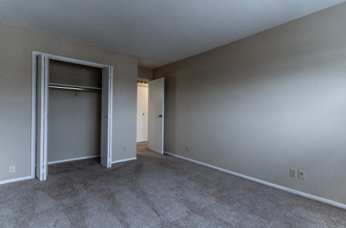 an empty living room with a door to a closet