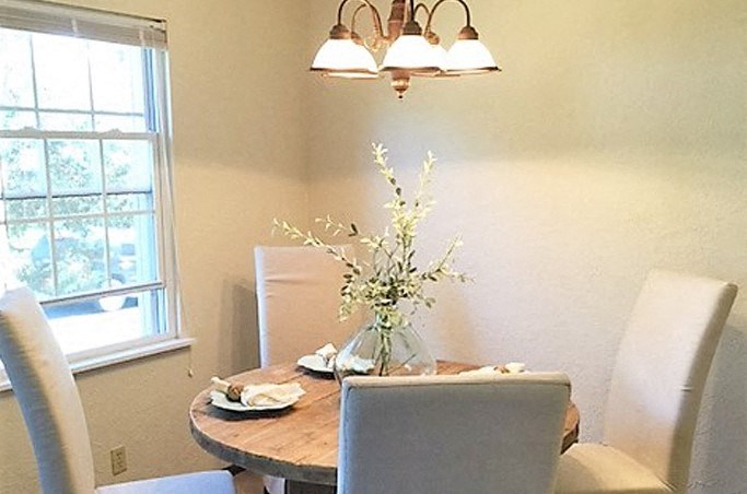 a dining room with a table and chairs and a window