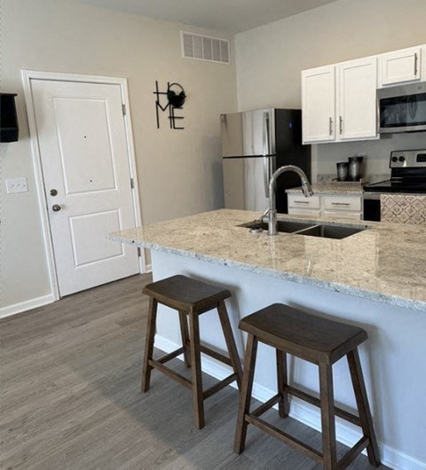 a kitchen with a marble counter top and two stools