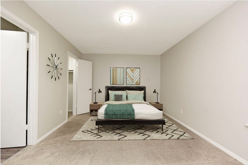 a bedroom with a bed and a door to a closet