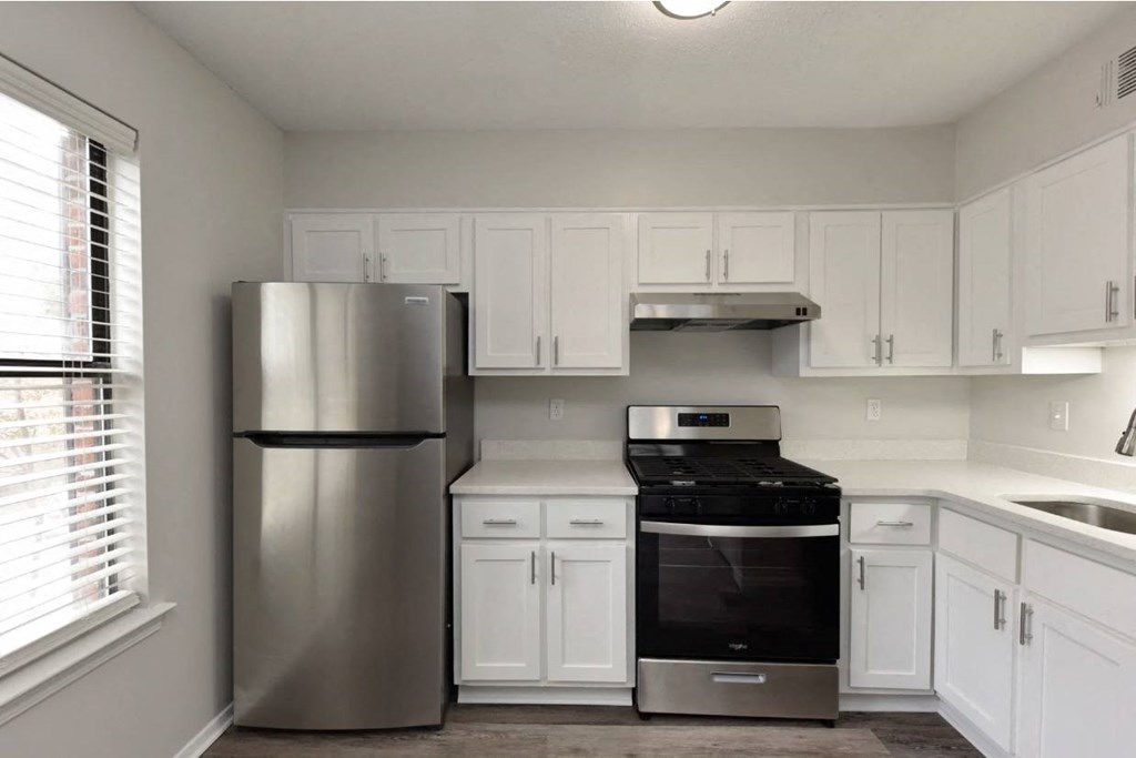 a kitchen with white cabinets and a stainless steel refrigerator
