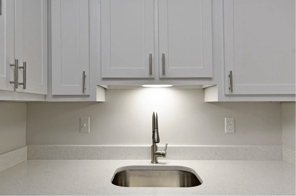 a kitchen with white cabinets and a sink