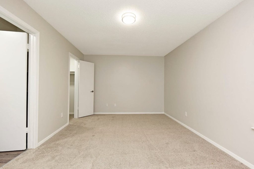 an empty living room with a door to a closet