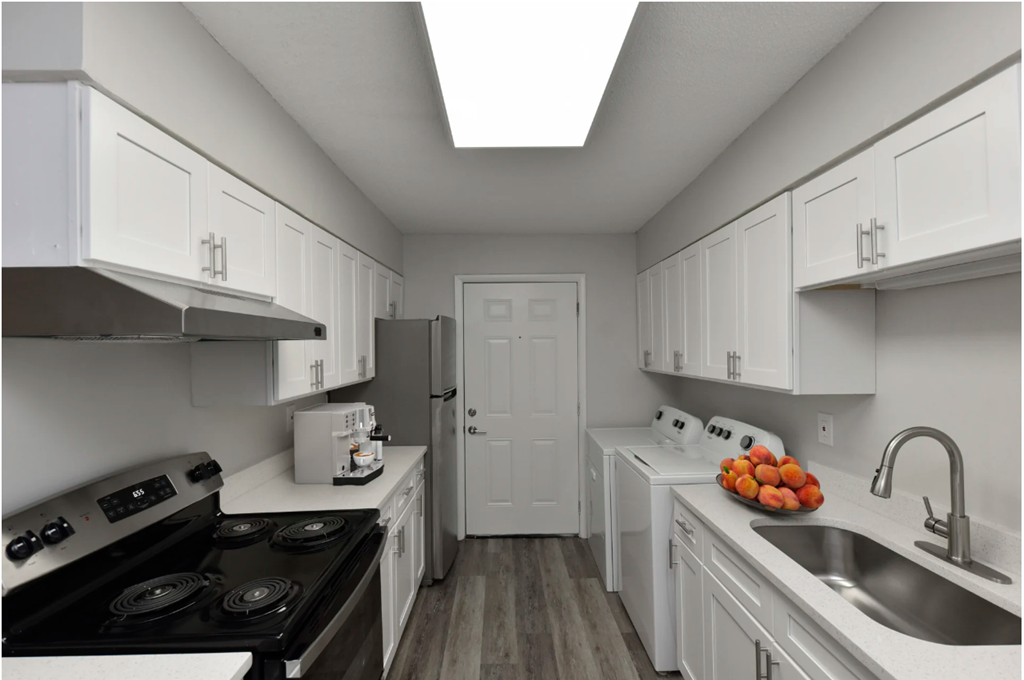 a kitchen with white cabinets and appliances and a sink