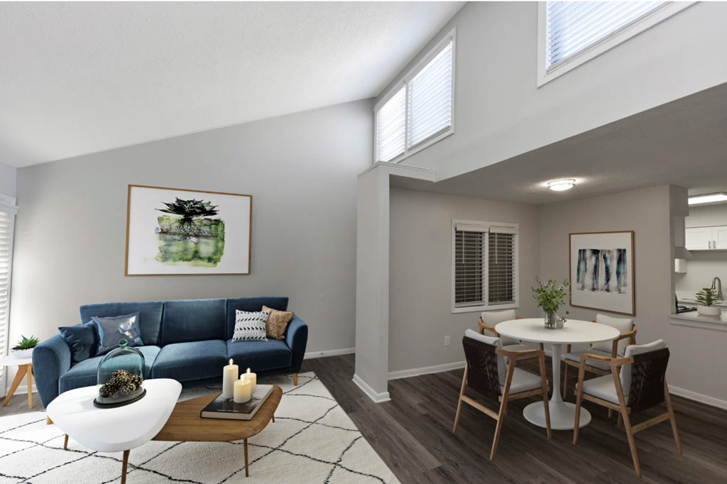 a living room with a blue couch and a dining room table