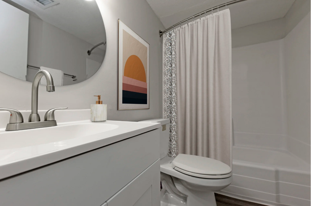 a bathroom with a shower and a sink and a toilet