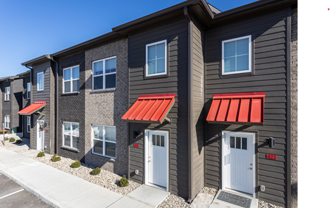A row of houses with red awnings on the front.
