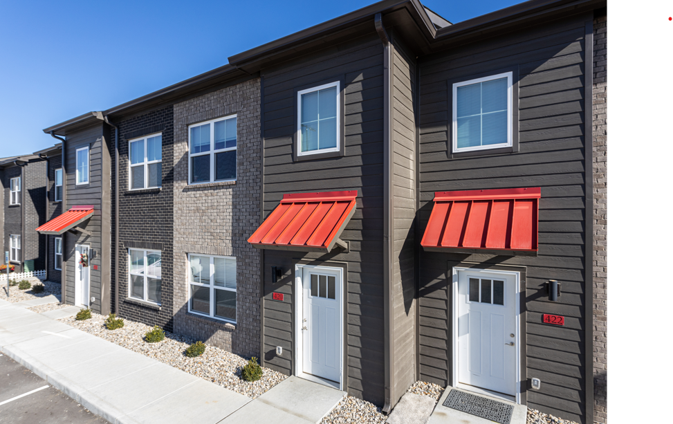 A row of houses with red awnings on the front.