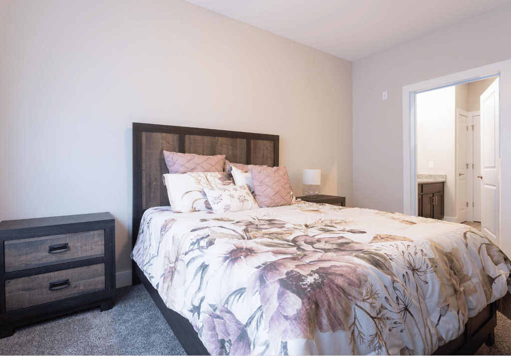 A bedroom with a large bed and a wooden headboard.