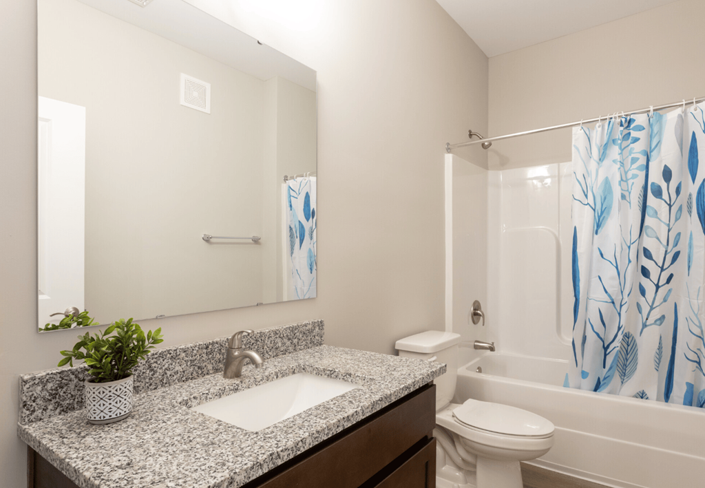 A bathroom with a granite countertop and a white sink.