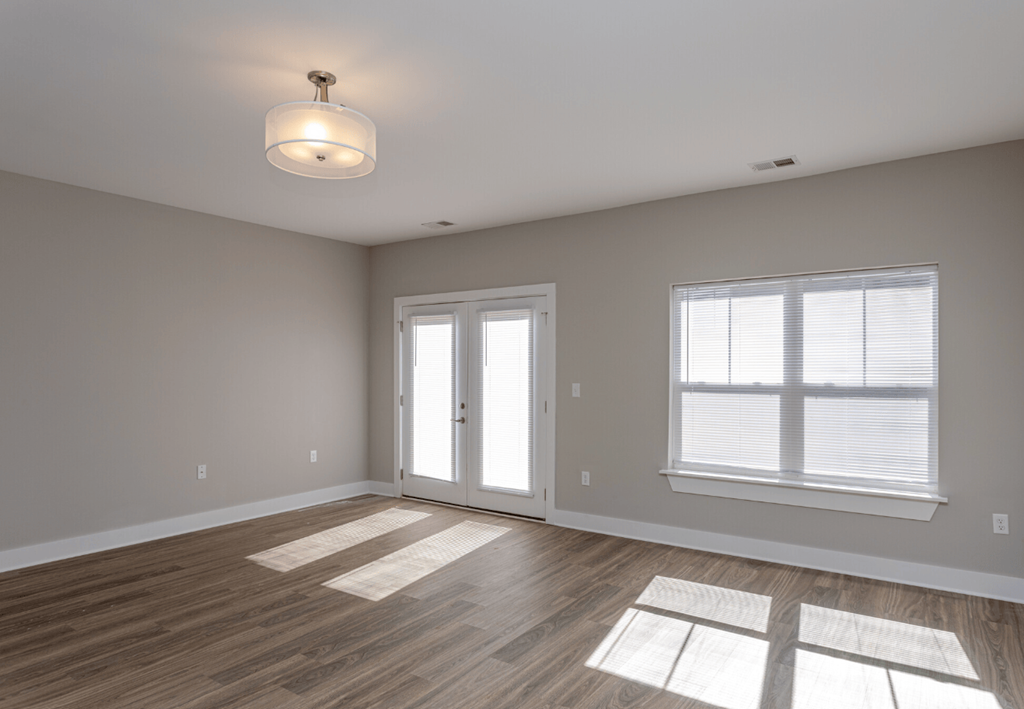 A room with a wooden floor and a large window.