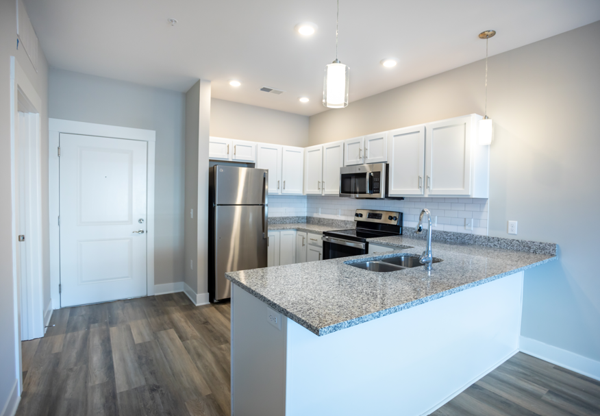 A kitchen with a granite countertop and stainless steel appliances.