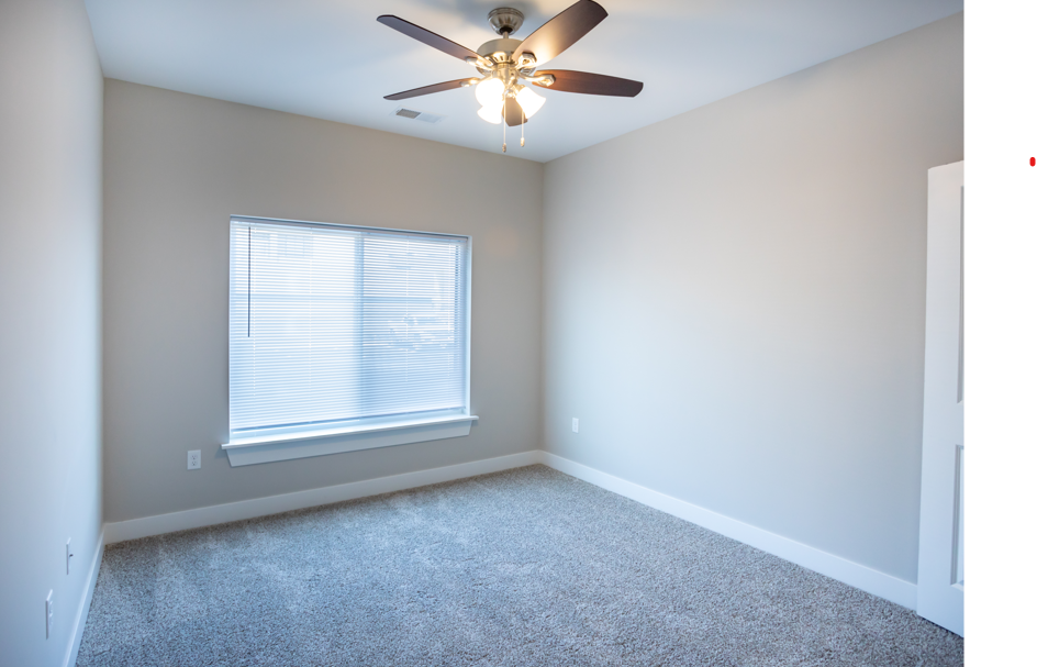 A room with a ceiling fan and a window.