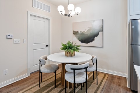 A dining room with a white table and chairs.
