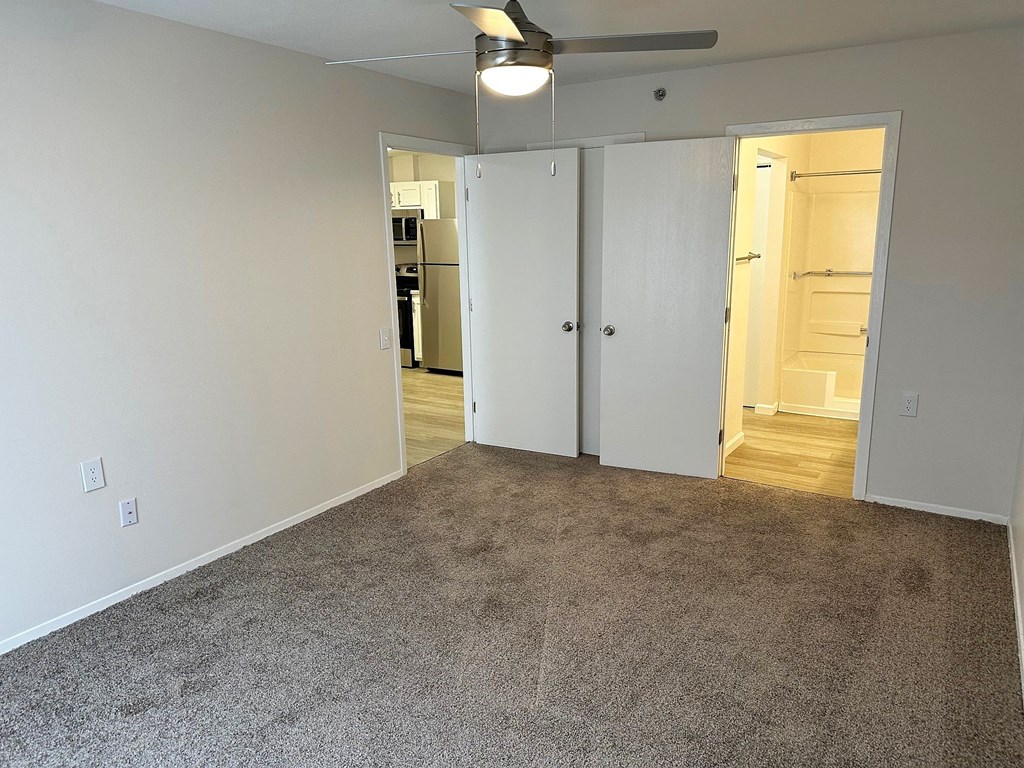 a bedroom with a carpeted floor and a ceiling fan