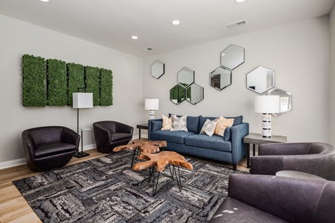 A living room with a grey rug and a blue couch.