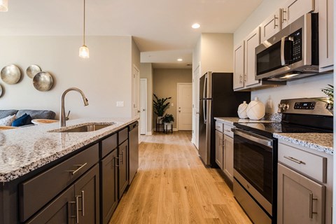A kitchen with black cabinets and a granite countertop.