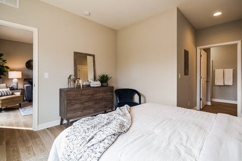 A bedroom with a large bed and a dresser with a mirror.