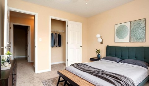 A bedroom with a bed, a dresser, and a mirror.