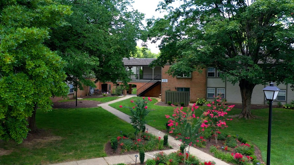 an aerial view of an apartment building with a lawn and flowers