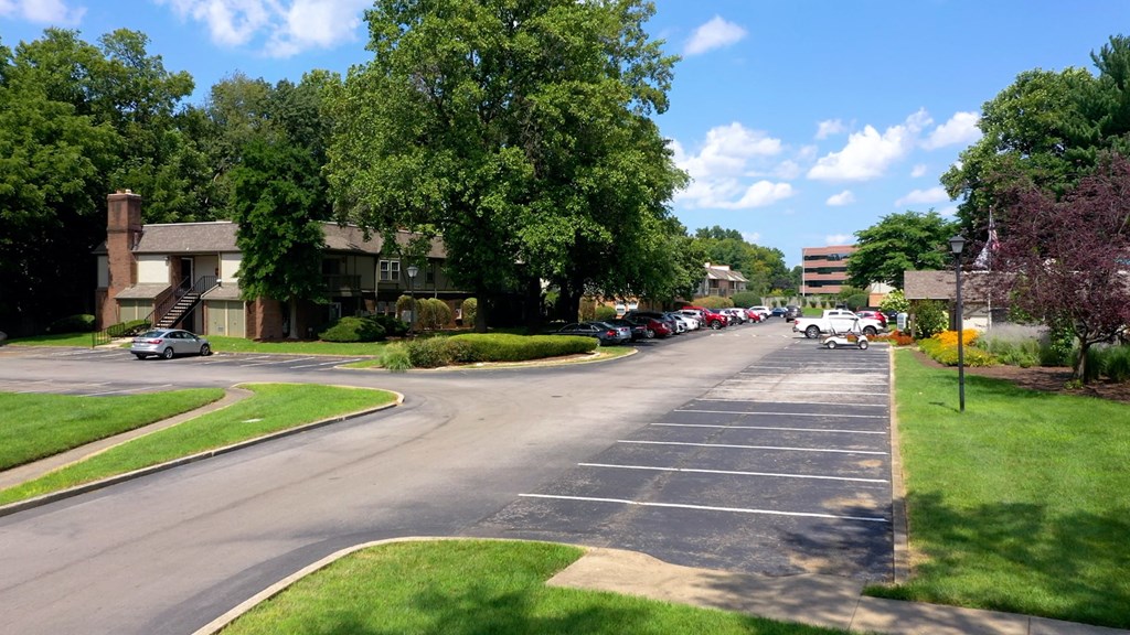a city street with cars parked in front of houses