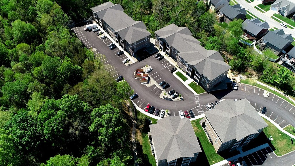 arial view of a building with a parking lot and trees