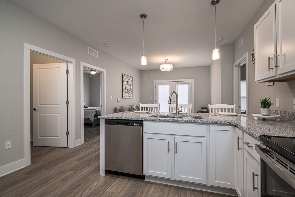 A kitchen with white cabinets and a granite countertop.