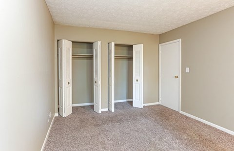 A room with a carpeted floor and a white door.