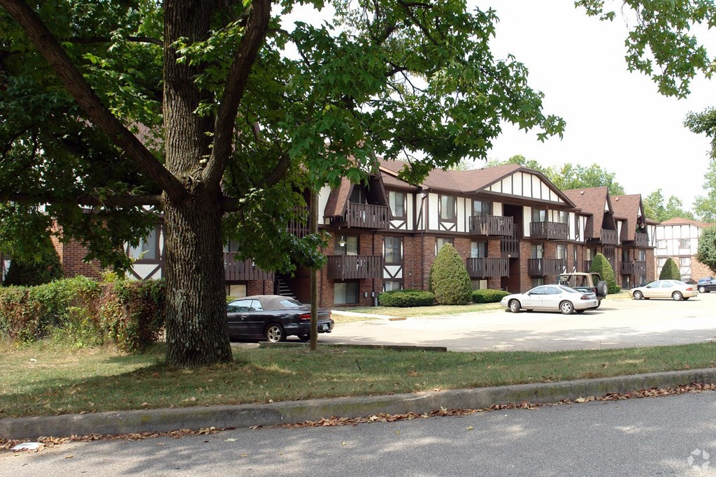 a large apartment building with cars parked in front of it