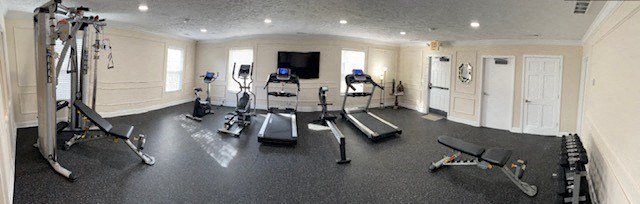 a gym with cardio equipment and weights on the floor