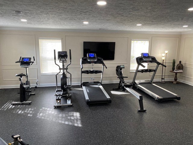 a workout room with weights and a tv