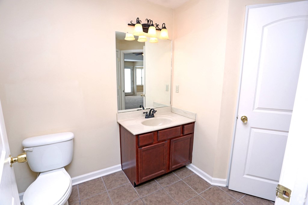 a bathroom with a toilet sink and a mirror