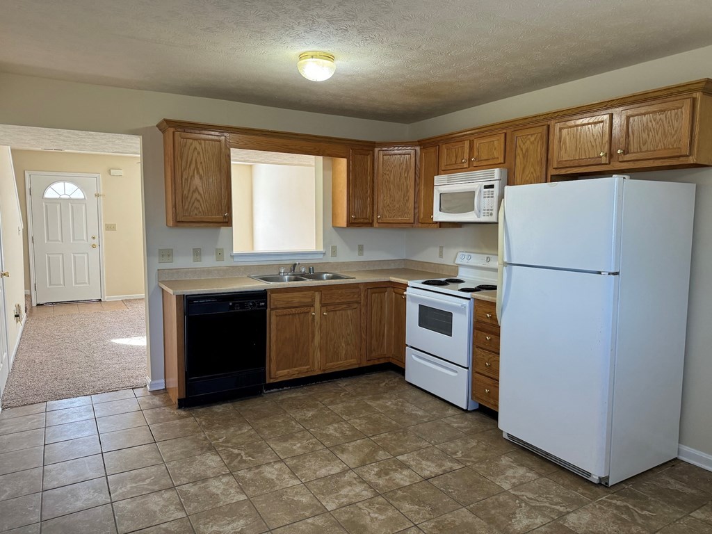 a kitchen with white appliances and wooden cabinets