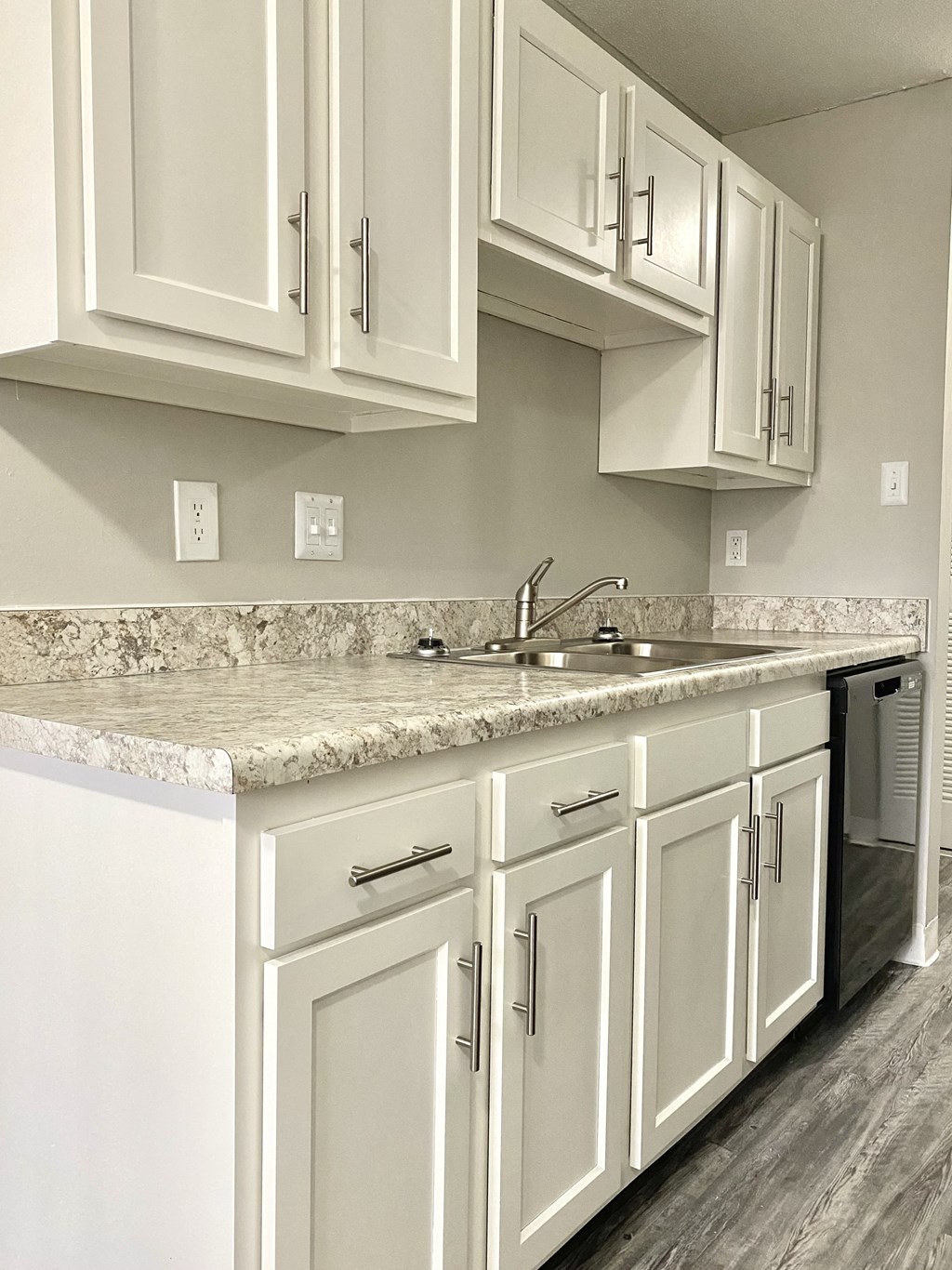 a kitchen with white cabinets and granite counter tops