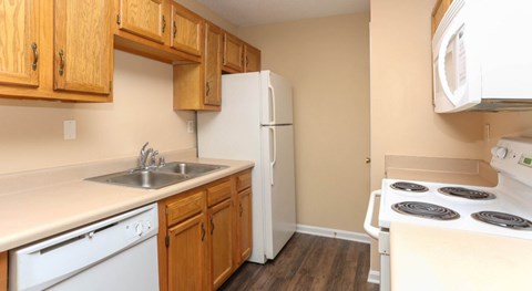 A kitchen with wooden cabinets and white appliances.