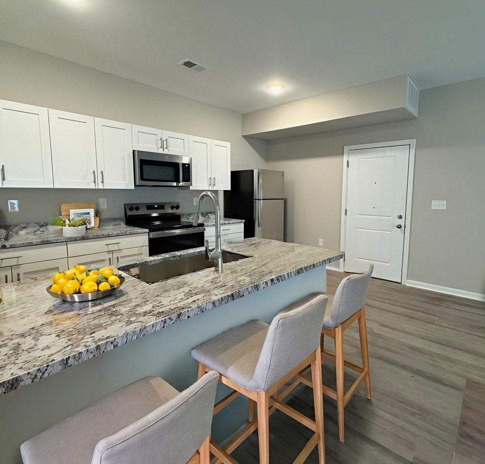 A kitchen with a marble countertop and a bowl of lemons on it.