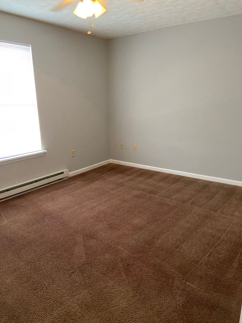 a room with a carpeted floor and a window