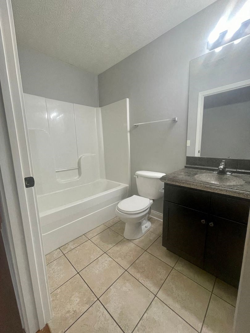 a bathroom with a toilet and a tub and a sink