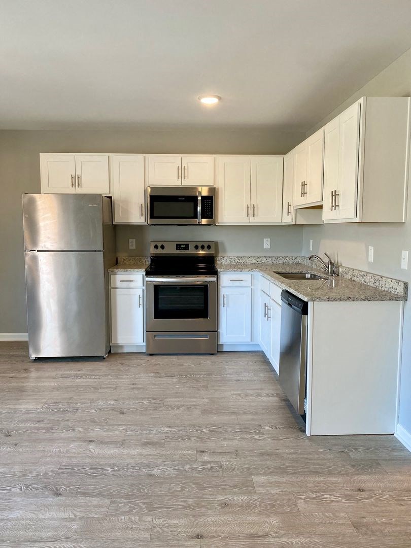a kitchen with stainless steel appliances and white cabinets
