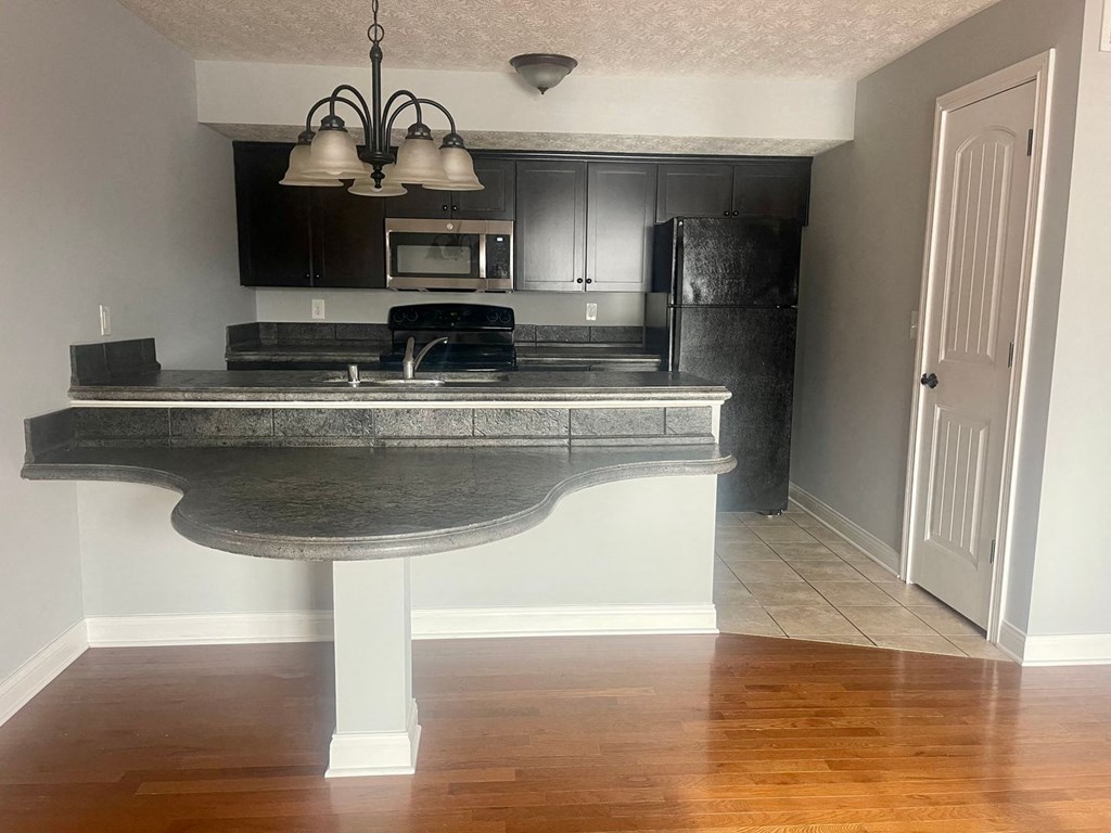 a kitchen with an island with a sink and a refrigerator