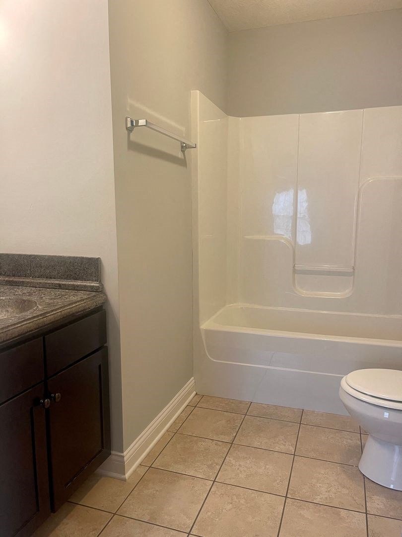 a bathroom with a toilet and a tub and a sink