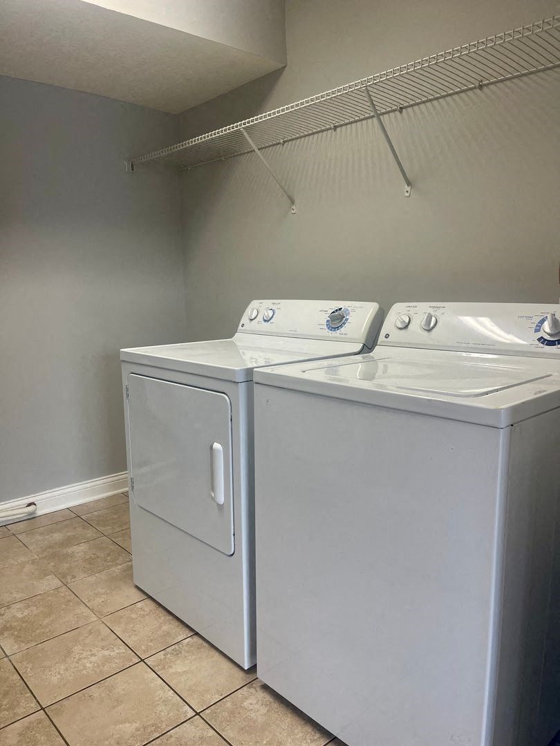 an empty laundry room with two washes and a dryer