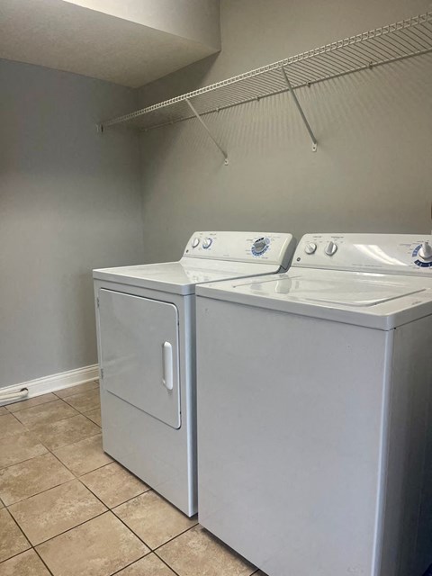 an empty laundry room with two washes and a dryer