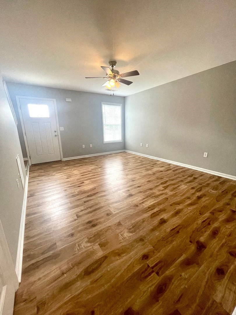 a living room with a hard wood floor and a ceiling fan